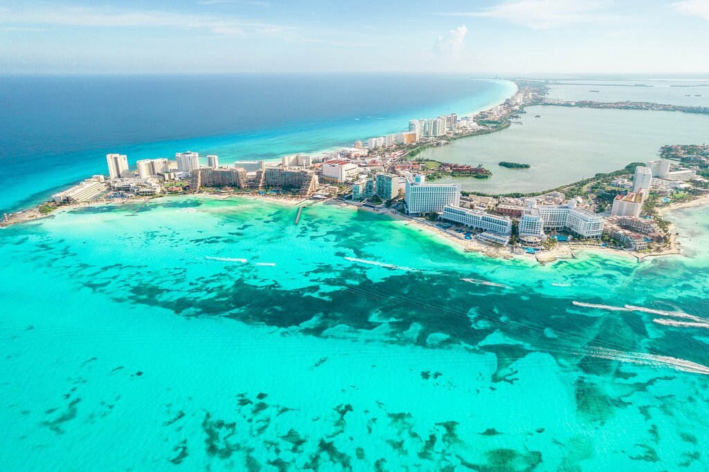Praia de areia branca com mar azul-turquesa transparente no Caribe